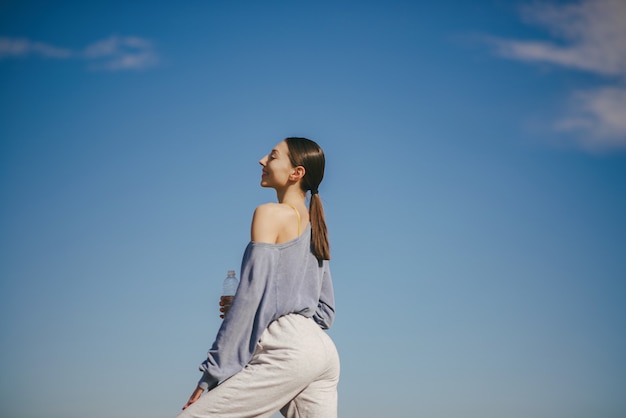 Foto gratuita linda chica entrenando en cielo azul