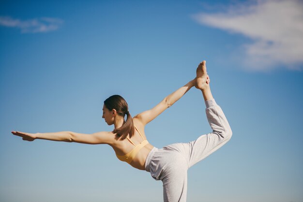 Linda chica entrenando en cielo azul