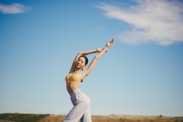 Linda chica entrenando en cielo azul