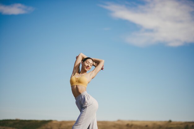 Linda chica entrenando en cielo azul