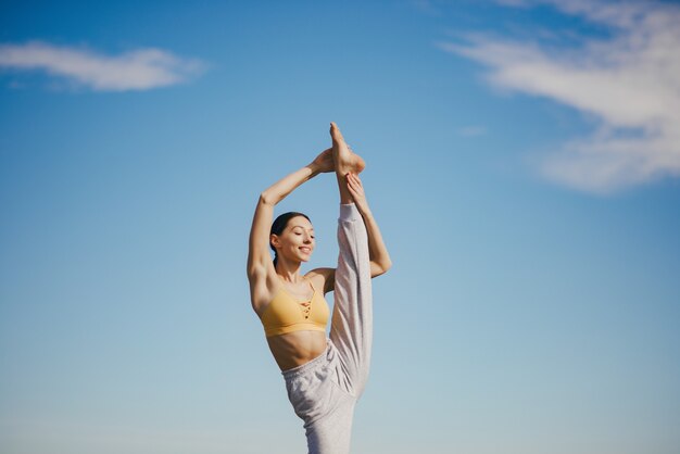 Linda chica entrenando en cielo azul