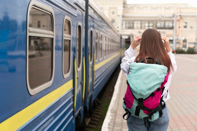 Linda chica en la estación de tren por detrás de tiro