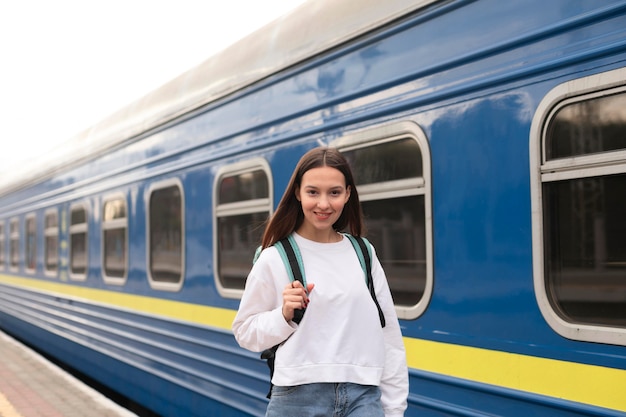 Linda chica en la estación de tren sonríe