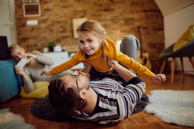 Linda chica feliz divirtiéndose con su padre en casa