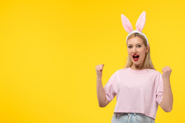 Linda chica guapa joven de Pascua con orejas de conejo emocionada levantando los puños