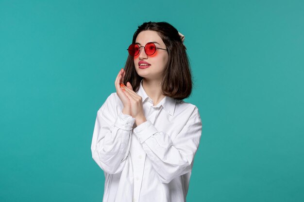 Linda chica guapa morena joven dulce en camisa blanca con gafas redondas rojas soñando