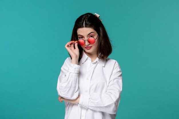 Linda chica guapa morena joven dulce con camisa blanca mirando por encima de las gafas