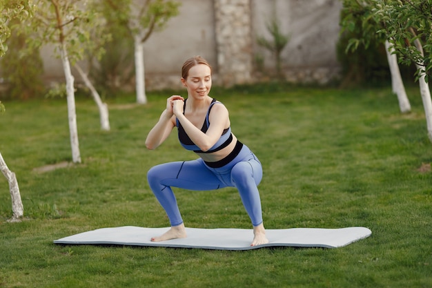 Foto gratuita linda chica haciendo yoga en un parque de verano