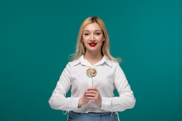 Linda chica joven adorable niña bonita en una camisa blanca limpia sosteniendo piruleta con dos bandas