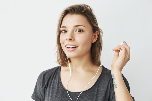 Linda chica joven en auriculares sonriendo.