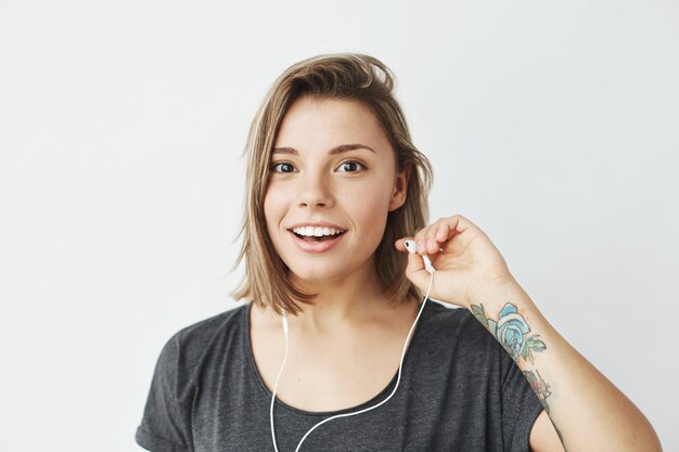 Linda chica joven en auriculares sonriendo.