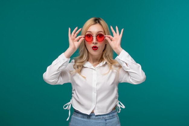 Linda chica joven bastante rubia en una camisa blanca con gafas rojas redondas