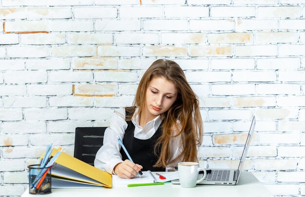 Linda chica joven que trabaja en el escritorio Foto de alta calidad