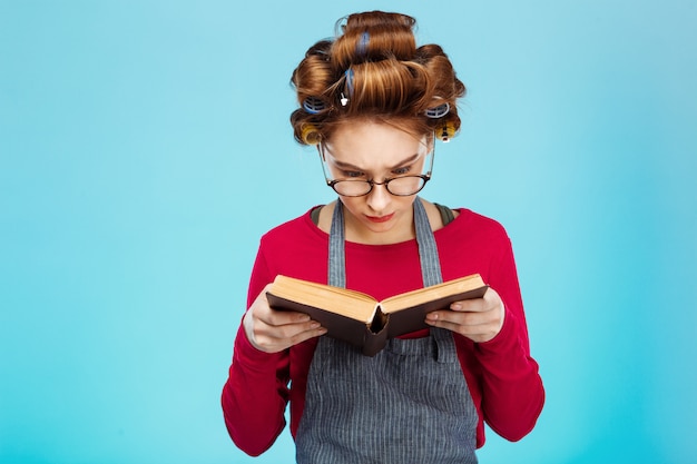 Foto gratuita linda chica lee el libro con gafas con rulos en el cabello