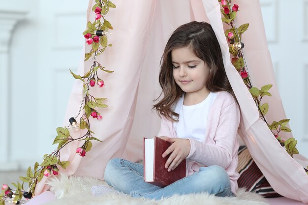 Linda chica leyendo un libro alrededor de linda decoración