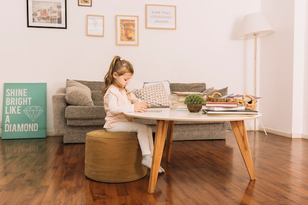 Foto gratuita linda chica leyendo en la mesa