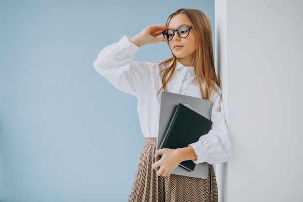 Linda chica con libro y portátil en la oficina