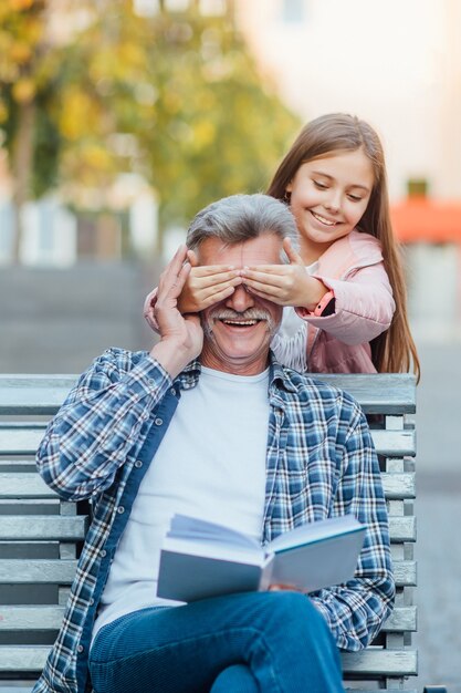 Linda chica lsmiling ittle pasar tiempo con el abuelo en el banco