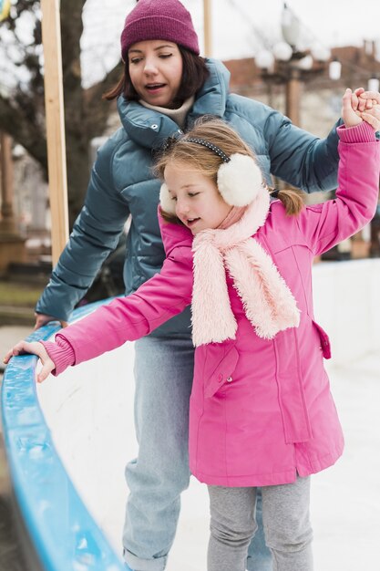 Foto gratuita linda chica y madre patinar sobre hielo