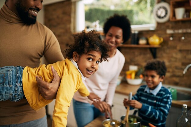 Linda chica negra divirtiéndose con su familia en casa