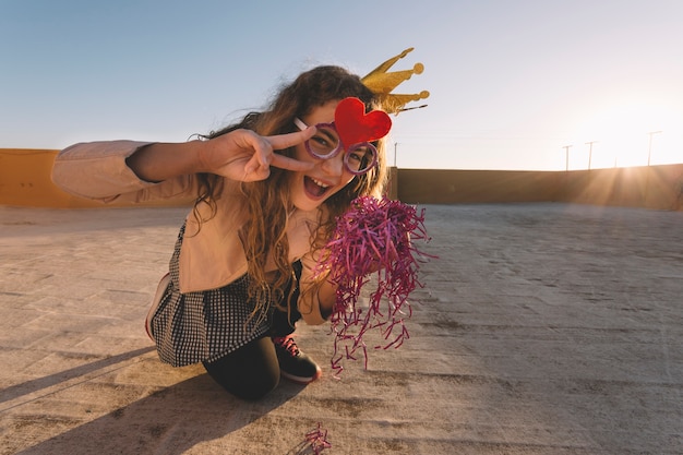 Foto gratuita linda chica con oropel gesticular paz