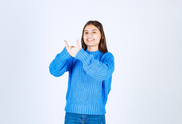 linda chica de pie y dando pulgar hacia arriba en blanco.