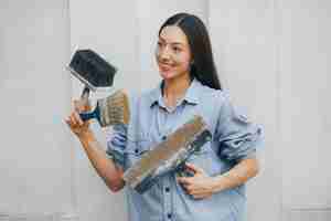 Foto gratuita linda chica de pie junto a la pared con herramientas de reparación