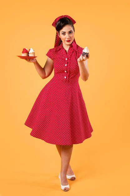 Linda chica pinup posando con cupcakes