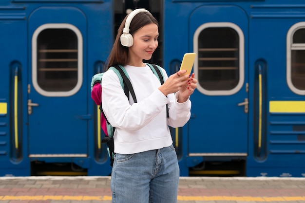 Foto gratuita linda chica en el plano medio de la estación de tren