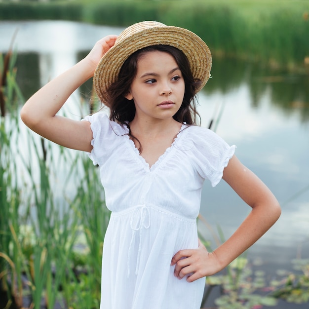 Linda chica posando junto al lago