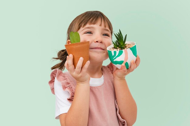 Linda chica con sesión de estudio de niño de plantas