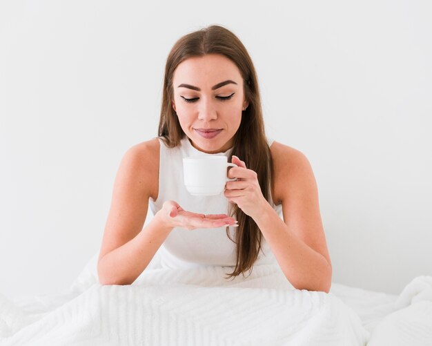 Linda chica tomando café en la cama