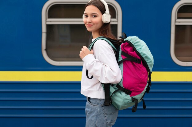 Linda chica de vista lateral en la estación de tren