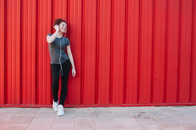 Linda deportista con auriculares en la calle