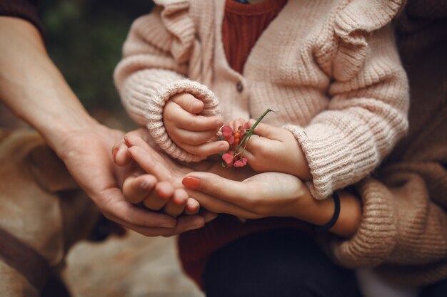 Linda y elegante familia jugando en un campo de otoño