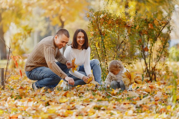 Linda y elegante familia jugando en un campo de otoño