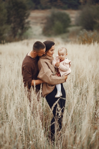 Linda y elegante familia jugando en un campo