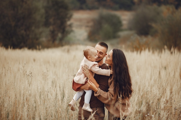 Linda y elegante familia jugando en un campo