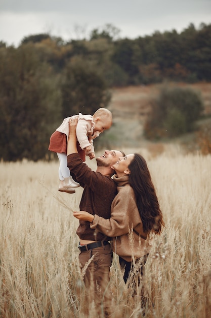 Linda y elegante familia jugando en un campo