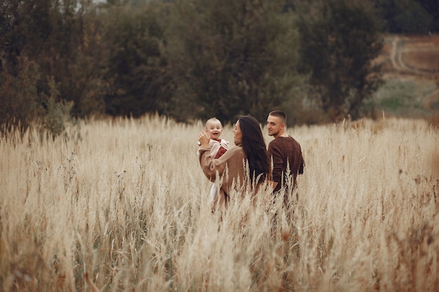 Linda y elegante familia jugando en un campo