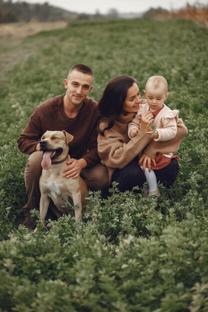 Linda y elegante familia jugando en un campo