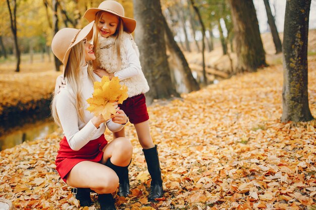 Linda y elegante familia en un parque de otoño