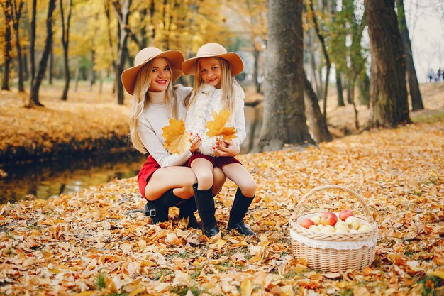 Linda y elegante familia en un parque de otoño