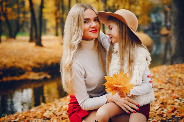 Linda y elegante familia en un parque de otoño