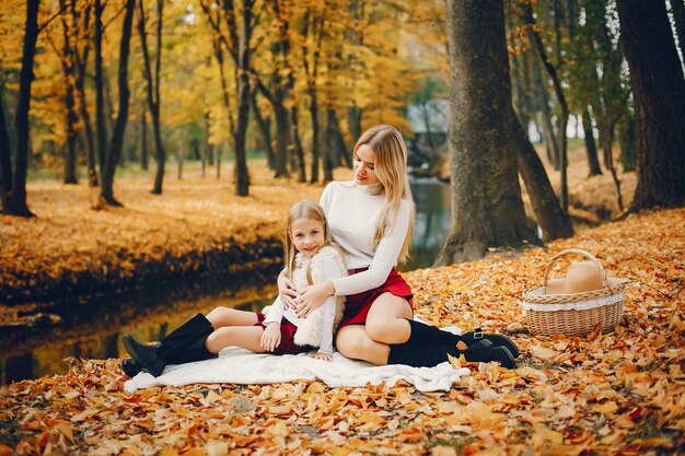 Linda y elegante familia en un parque de otoño