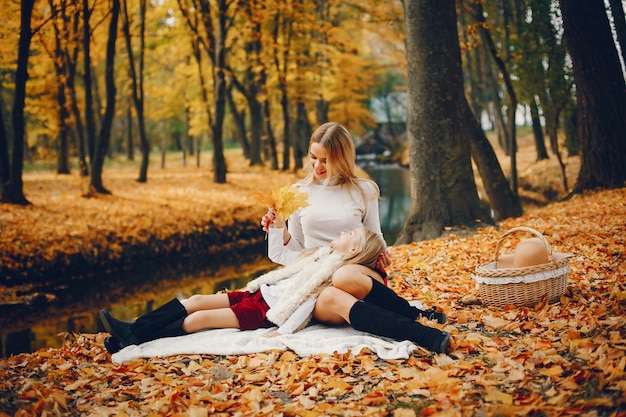 Linda y elegante familia en un parque de otoño