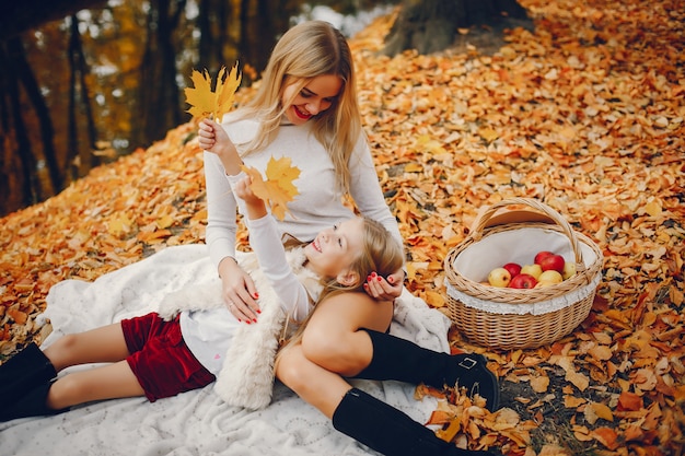 Linda y elegante familia en un parque de otoño