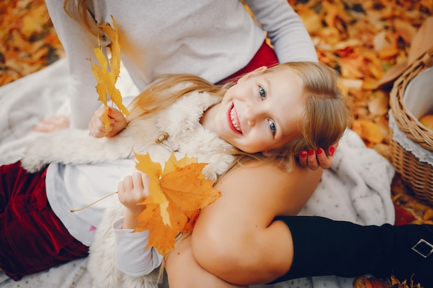 Linda y elegante familia en un parque de otoño