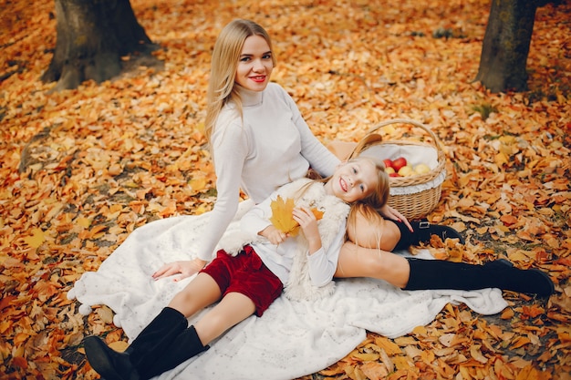 Linda y elegante familia en un parque de otoño