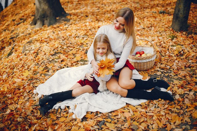 Linda y elegante familia en un parque de otoño